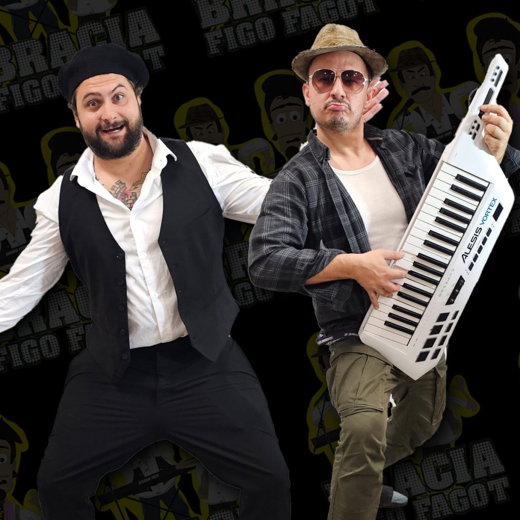 Dwóch mężczyzn na czarnym tle z graficznym wzorem. Jeden ubrany w białą koszulę, czarną kamizelkę i beret, wykonuje energiczny gest taneczny. Drugi ma na sobie kapelusz, okulary przeciwsłoneczne i koszulę w kratę, trzyma biały keytar. Obaj pozują dynamicznie, w koncertowym klimacie.